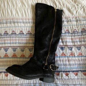 Long black boots with gold buckle